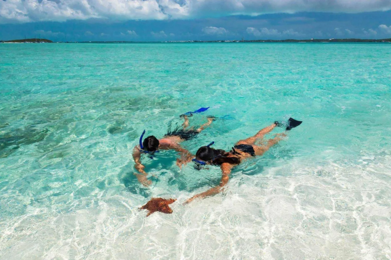 Couple snorkeling at Sandals Emerald Bay in The Bahamas